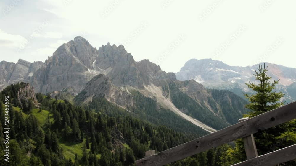 Amazing view of the rocky Dolomite mountains. View shot from Longkufel, Dobbiaco, detailing the mountains, the pine forest and the typical Italian wooden fences. Amazing view of the rocky Dolomite mountains. View shot from Longkufel, Dobbiaco, detailing the mountains, the pine forest and the typical Italian wooden fences.