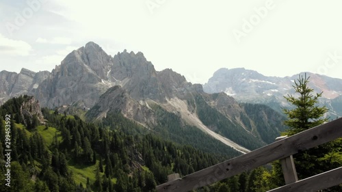 Amazing view of the rocky Dolomite mountains. View shot from Longkufel, Dobbiaco, detailing the mountains, the pine forest and the typical Italian wooden fences. photo