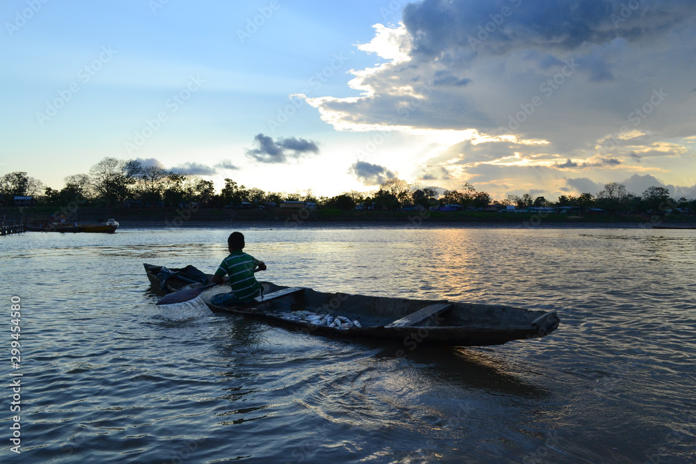 Indigenous boy returns home after a day of fishing in the Colombian Amazon