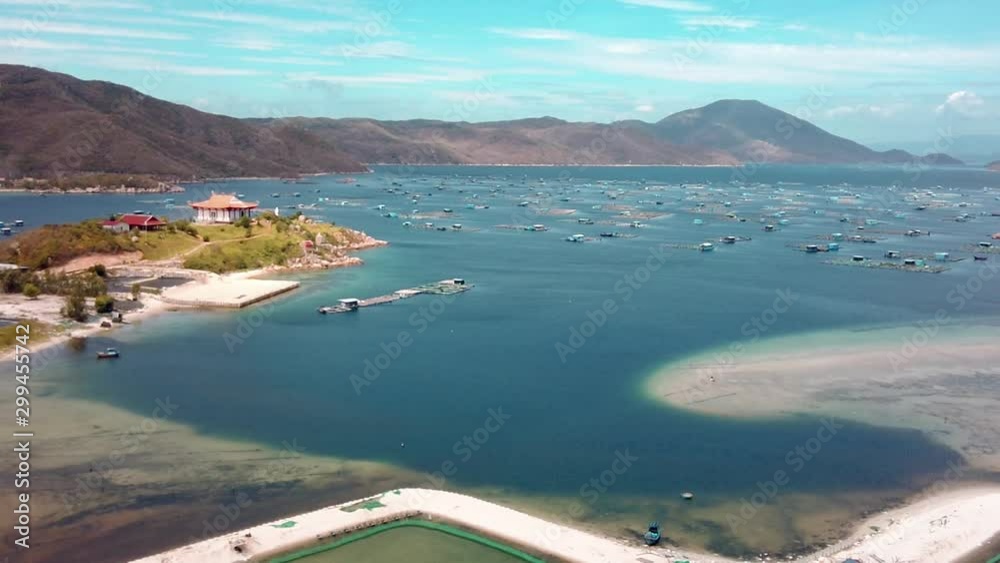 Van phong Bay aerial view establishing shot Floating mariculture fish cages, marine shrimp farming grow-out ponds, coastal buddhist temple, Whale Island. Khanh Hoa province Vietnam Van phong Bay aerial view establishing shot Floating mariculture fish cages, marine shrimp farming grow-out ponds, coastal buddhist temple, Whale Island. Khanh Hoa province Vietnam