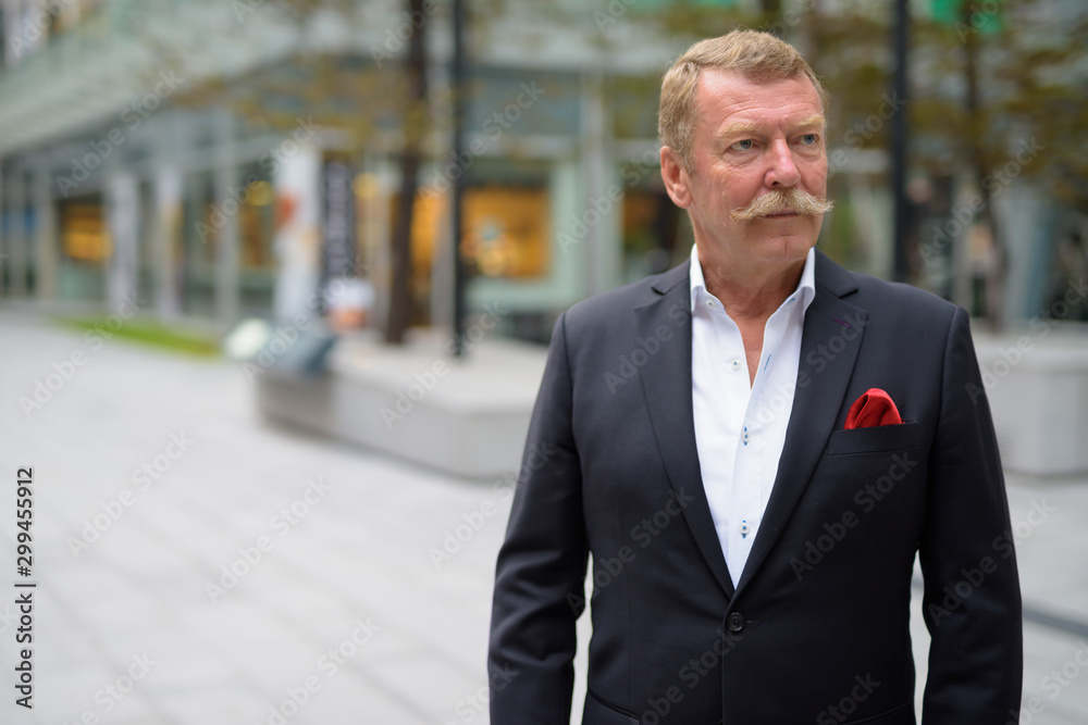 Handsome senior businessman with mustache exploring the city