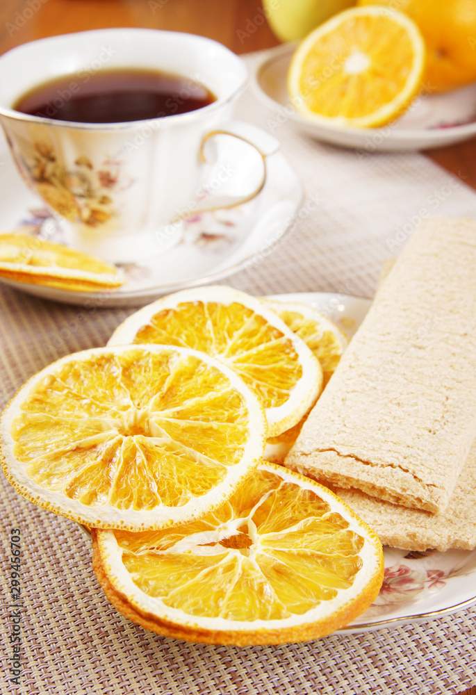 Breakfast with tea and fruit chips made of oranges and crispbreads. Healthy vegetarian dietary food Breakfast with tea and fruit chips made of oranges and crispbreads. Healthy vegetarian dietary food