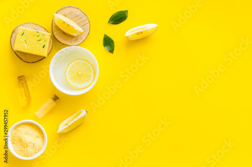 Lemon cosmetics. Cleansing tonic and handmade soap on yellow background top view frame copy space