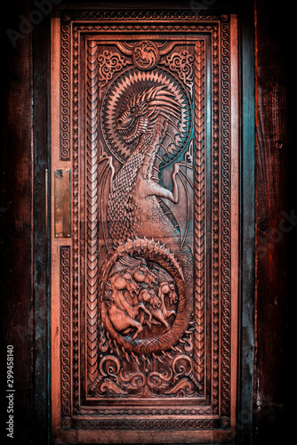 фотографія BALLINTOY HARBOUR, NORTHERN IRELAND, DECEMBER 20, 2018: Magnificent carved door with dragons and Dothraki horses, made with wood from the Dark Hedges