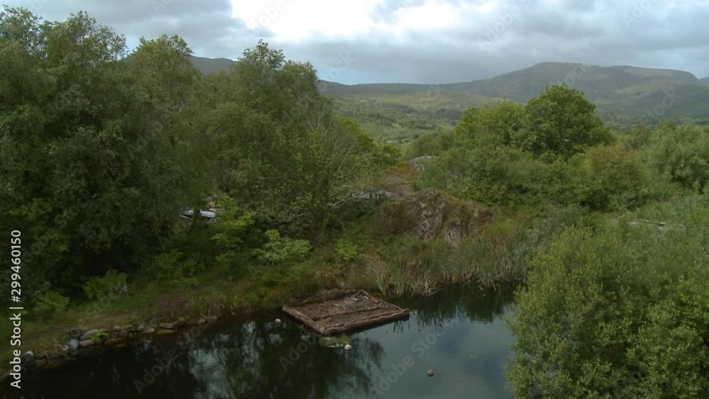 Wide shot looking across a small pond with a wooden dock, at a distant mountain ridge Wide shot looking across a small pond with a wooden dock, at a distant mountain ridge