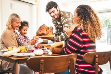 Thanksgiving Celebration Tradition Family Dinner Concept.family having holiday dinner and cutting turkey.Young black adult woman and her daughter happy..