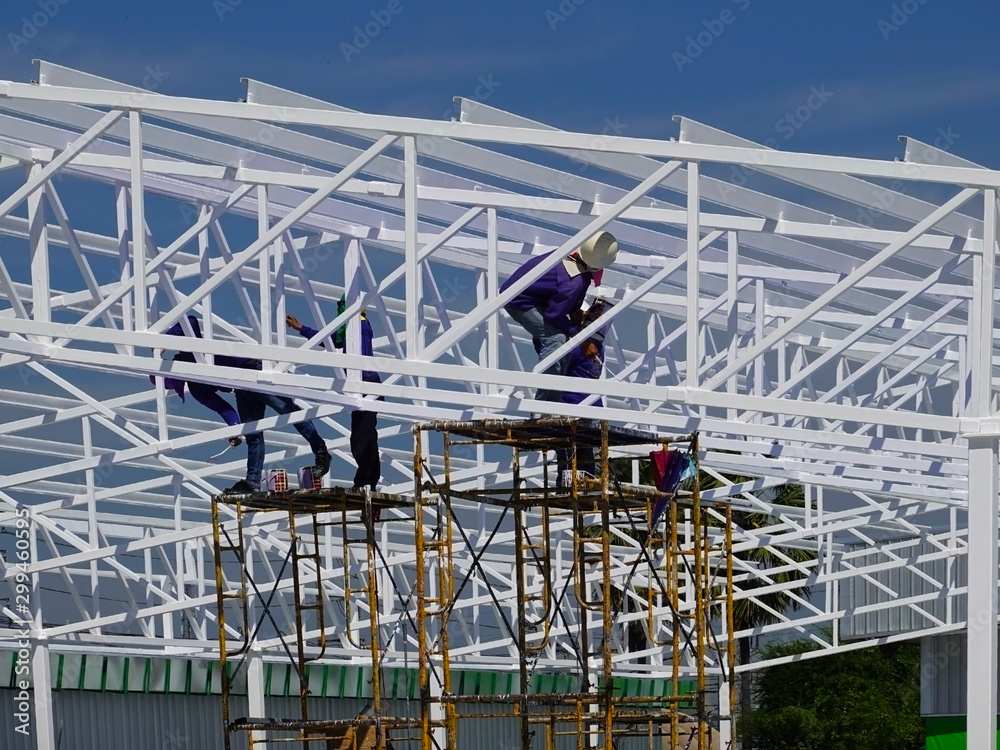 Workers painted the roof structure on the construction site Workers painted the roof structure on the construction site