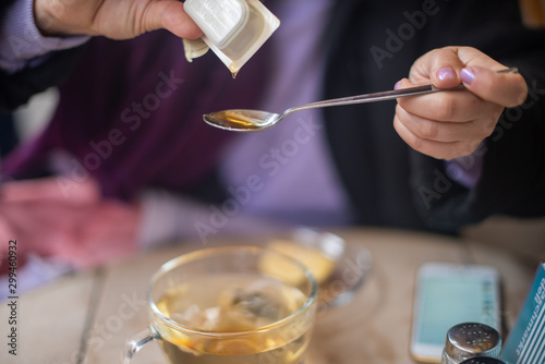 Woman throwing honey on spoon