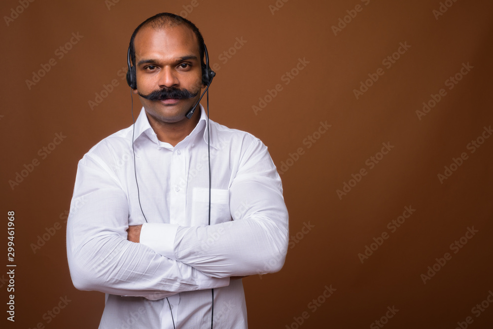 Fototapeta premium Portrait of Indian businessman with mustache as call center representative