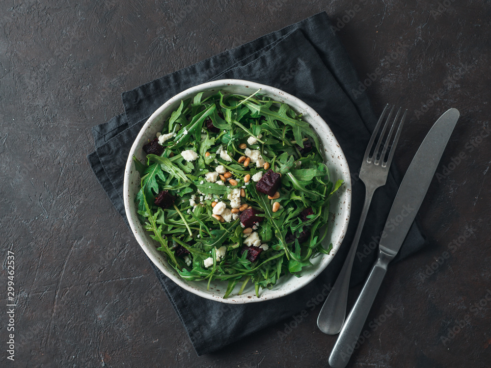 Beetroot, aragula and soft cheese salad over black background. Top view or flat lay. Copy space for text. Idea and recipe for healthy vegetarian salad. Clean eating diet concept Beetroot, aragula and soft cheese salad over black background. Top view or flat lay. Copy space for text. Idea and recipe for healthy vegetarian salad. Clean eating diet concept