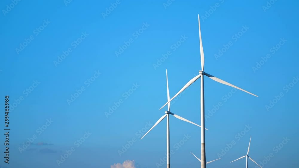 Close up windmill rotating on the blue sky. A wind turbine is a machine can receive and convert the kinetic energy from the movement of the wind into mechanical energy. Close up windmill rotating on the blue sky. A wind turbine is a machine can receive and convert the kinetic energy from the movement of the wind into mechanical energy.