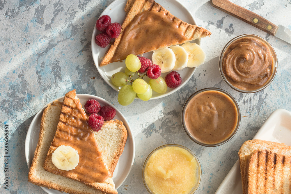 Homemade toast bread with jam and variety peanut almond butter on wood table for breakfast. Delicious toast bread ready to served. Homemade toast bread with jam and variety peanut almond butter on wood table for breakfast. Delicious toast bread ready to served.