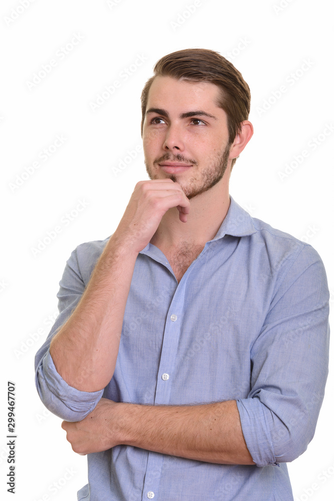 Portrait of young handsome bearded businessman thinking and looking up Portrait of young handsome bearded businessman thinking and looking up
