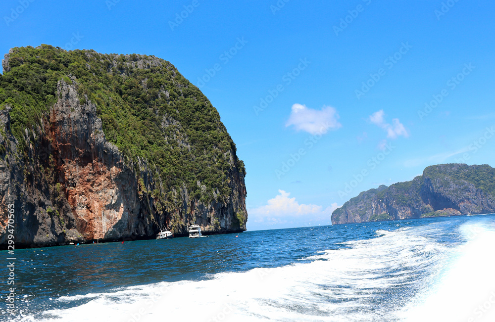 boat ride on the sea, exotic James Bond islands against the blue sea, waves of spray in Thailand