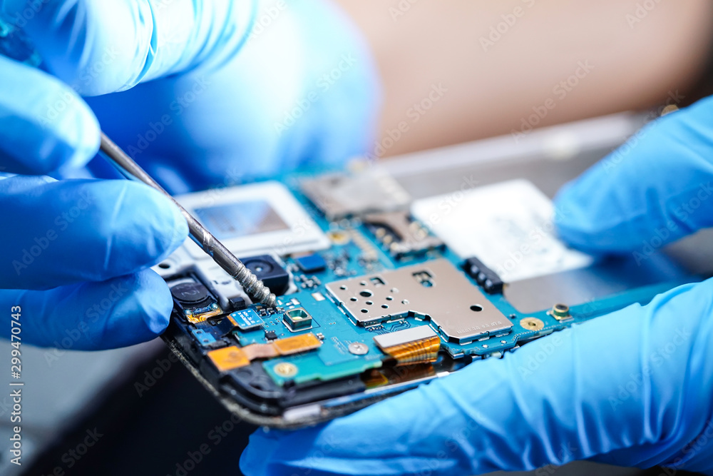 Asian Technician repairing micro circuit main board of smartphone ...