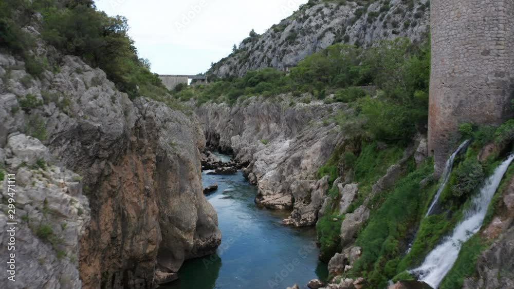 Flying over mountain river with small waterfall Flying over mountain river with small waterfall
