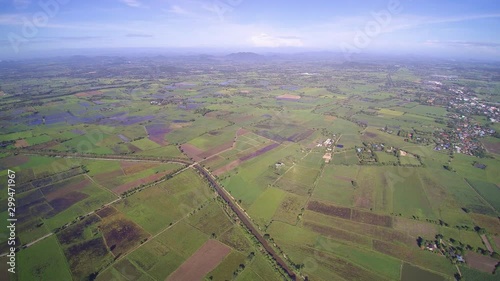 Vdo. Aerial view above green rice paddy fields plantation with many clouds and blue sky background, Lam Phayom District in Ban Pong, Ratchabur i- Kanchanaburi, western of Thailand. photo