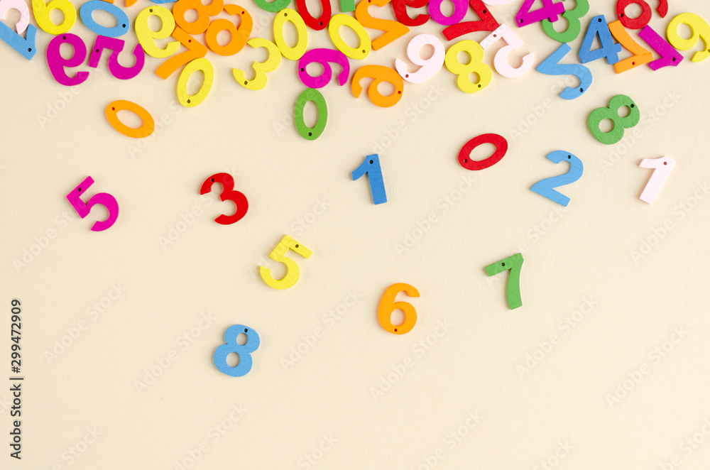 Colored wooden numbers composition on beige background.