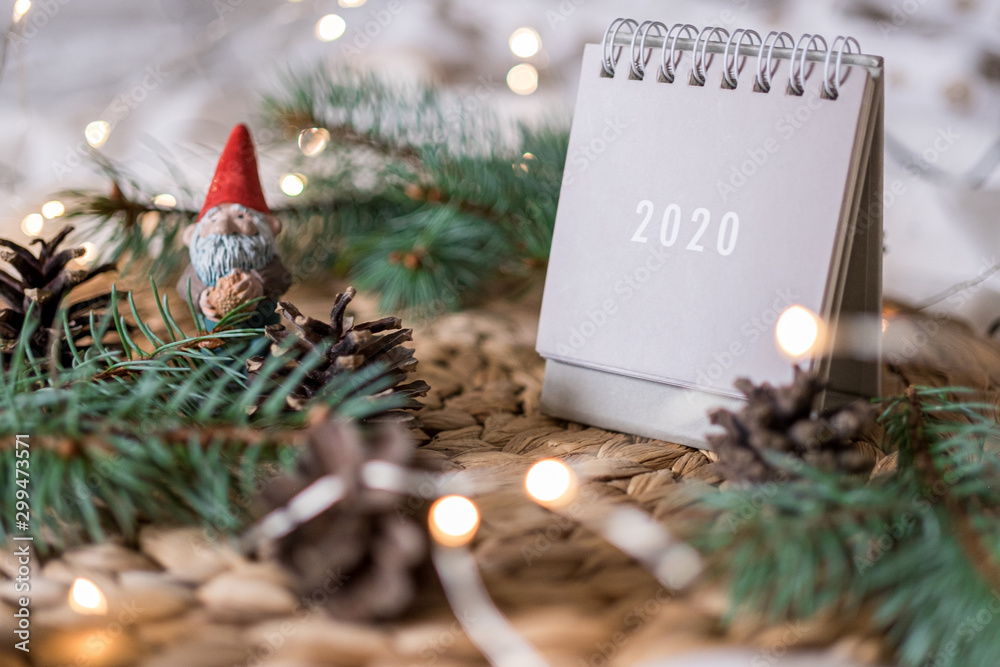 New Year 2020 calendar with lights on rustic server with cones and toys - obrazy, fototapety, plakaty 