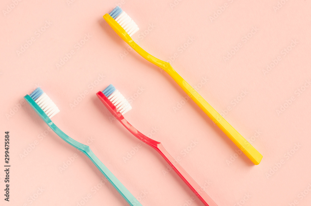 Colored toothbrushes composition on pink background. Flat lay. Colored toothbrushes composition on pink background. Flat lay.