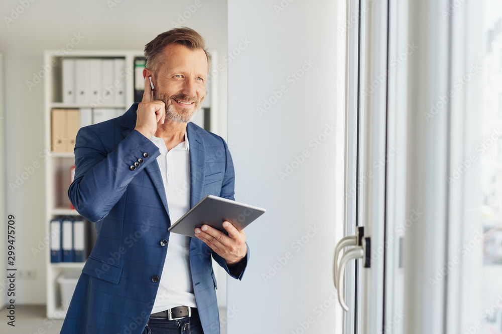 Fototapeta premium Businessman listening to audio on an ear bud