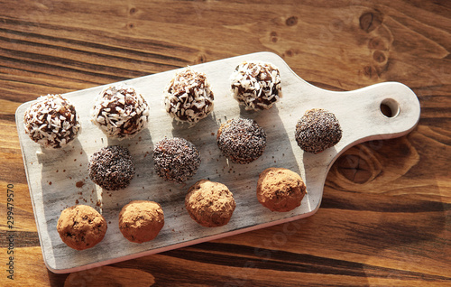 Homemade healthy energy vegan raw sweet balls made of dried fruits and nuts on wooden plate. Dessert with no added sugar, healthy diet food concept. Selective focus. Top view, flat lay.          photo