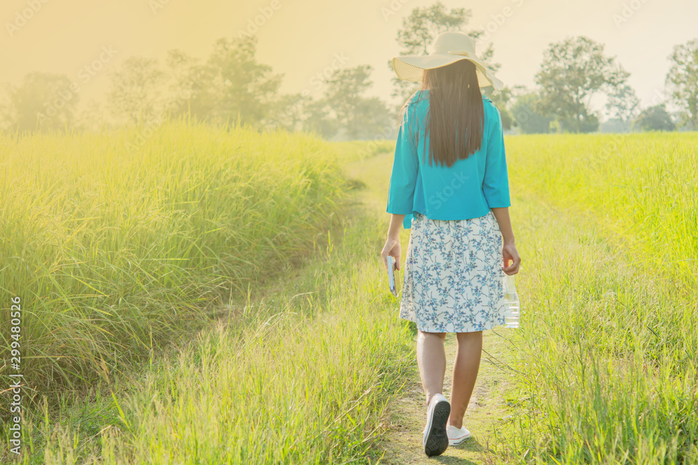  water bottle in the hand the girl and with books and phones Mobile phone and afternoon sunshine Green nature