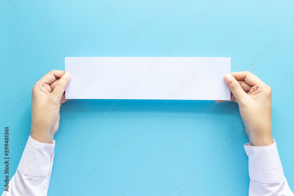 Close up hands holding empty white blank horizontal paper for flyer or