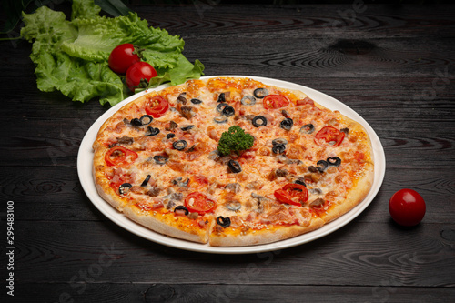 assorted pizza sliced into pieces with cheese, tomato and olives