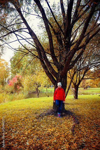Girl is walking in the Park in autumn and she is standing on the shore of a pond