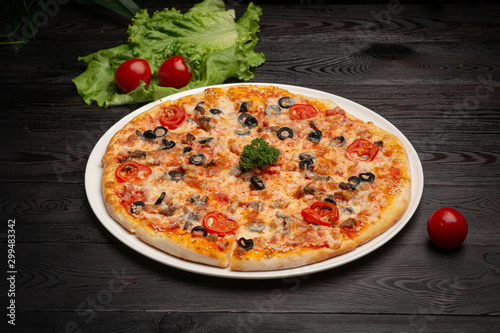 assorted pizza sliced into pieces with cheese, tomato and olives