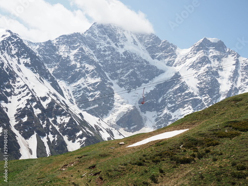 Beautiful mountain landscape of Caucasus. View of glacier named Seven. View of mountains Donguz - Orun, Nakra. Landscape with snow peaks, white clouds and green hills
