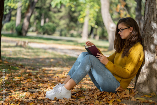 Woman sitting in park and reading book