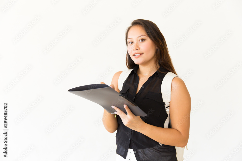 Woman with backpack holding folder. Beautiful young female student with backpack holding folder and smiling at camera. Education concept Woman with backpack holding folder. Beautiful young female student with backpack holding folder and smiling at camera. Education concept
