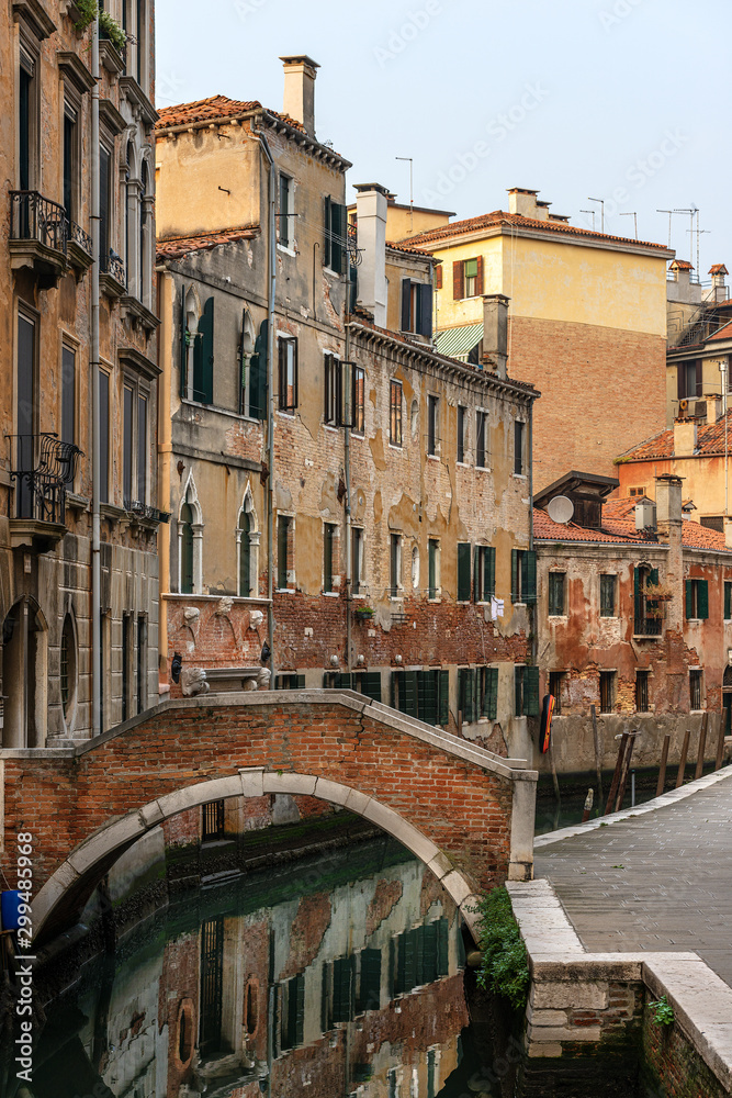 Venice, foreshortening of the city with a small bridge over a canal of the Venetian lagoon and old houses. UNESCO world heritage site, Italy, Europe