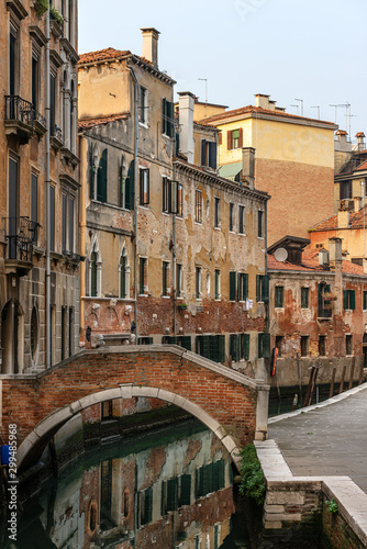 Venice, foreshortening of the city with a small bridge over a canal of the Venetian lagoon and old houses. UNESCO world heritage site, Italy, Europe © Alberto Masnovo