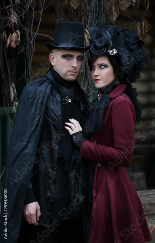 The sinister young couple wearing old-fashioned vampire-style clothes