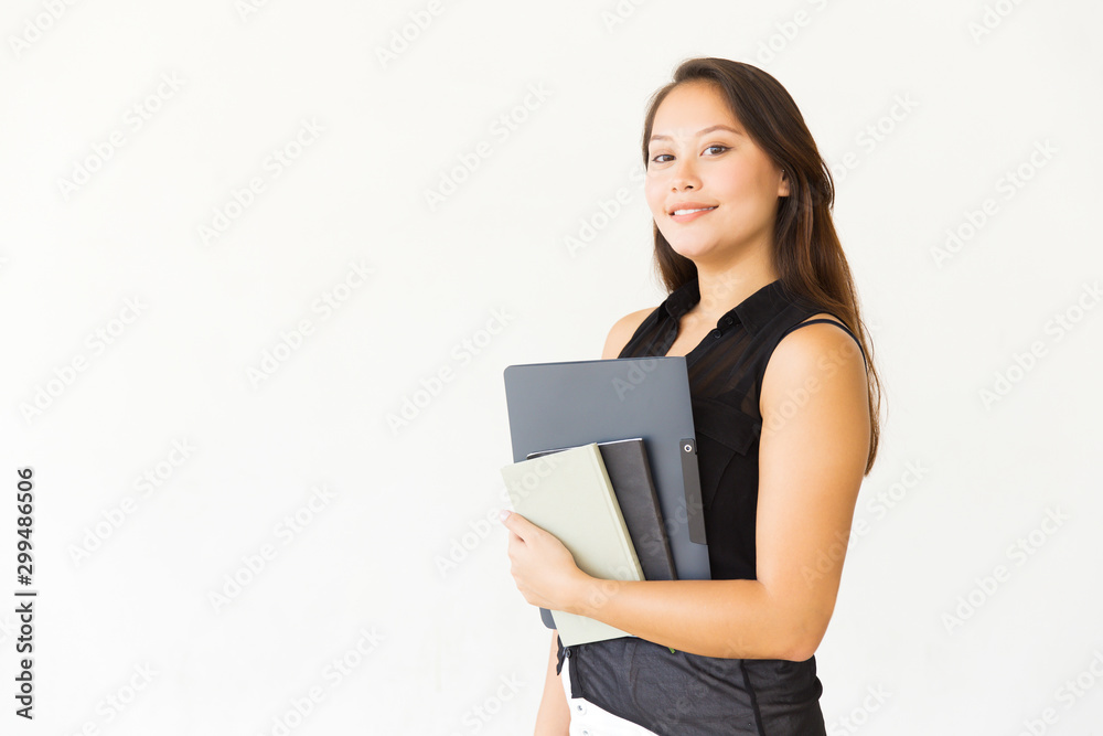 Attractive content woman holding folder and books. Beautiful cheerful young female student holding folder and smiling at camera on white background. Education concept Attractive content woman holding folder and books. Beautiful cheerful young female student holding folder and smiling at camera on white background. Education concept