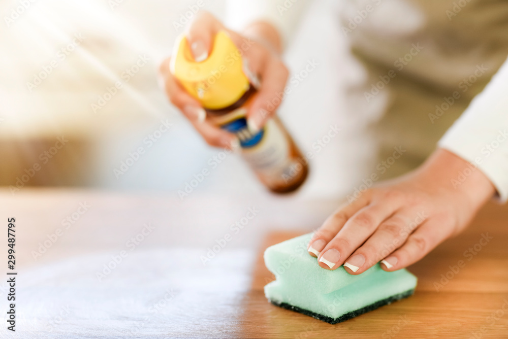 Woman use green sponge for cleaning wood in modern kitchen. Cleaning old table with spray and cloth. Woman use green sponge for cleaning wood in modern kitchen. Cleaning old table with spray and cloth.
