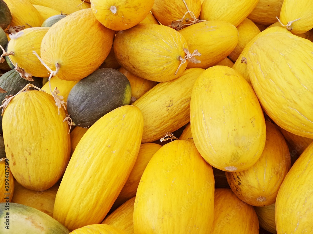 Bright juicy melon close-up. Yellow oblong melons on counter of bazaar or greengrocer. Selective focus image. Bright juicy melon close-up. Yellow oblong melons on counter of bazaar or greengrocer. Selective focus image.
