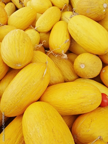 Bright juicy melon close-up. Yellow oblong melons on counter of bazaar or greengrocer. Selective focus image.