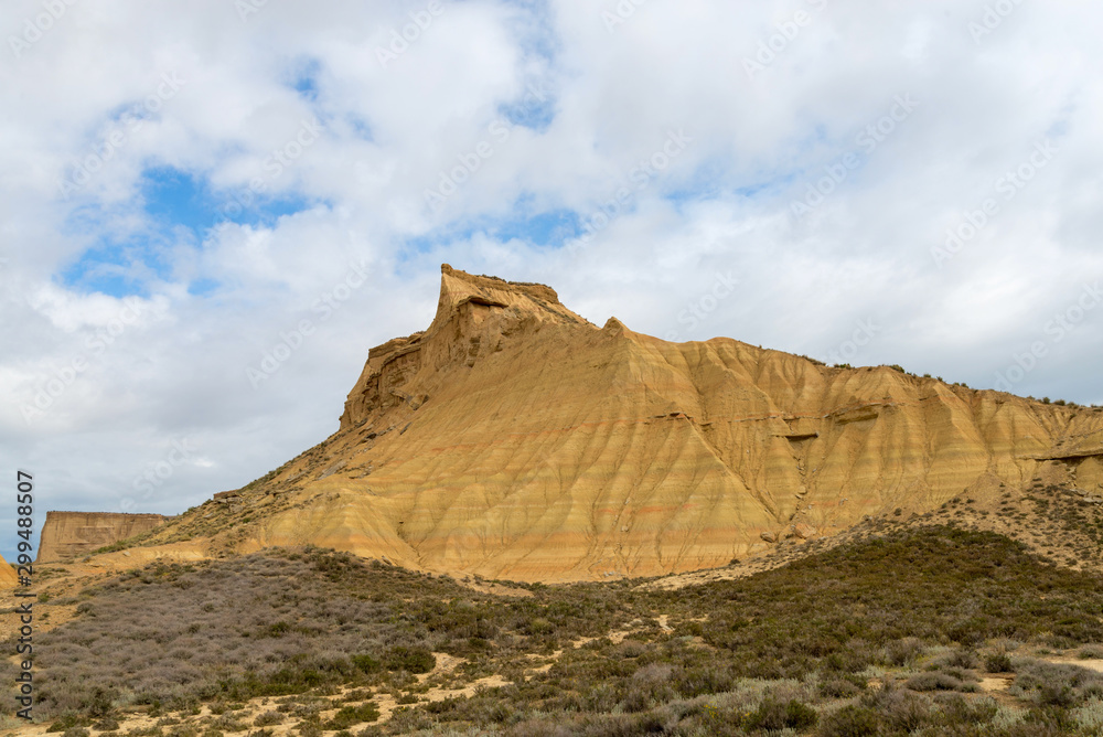 Steep mountain with a shrubby foothill in the badlands Bardenas Reales