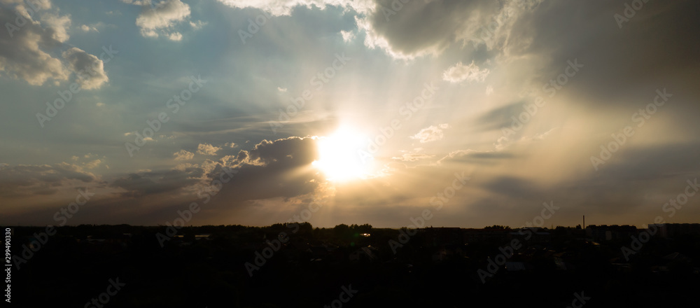 Bright sun at sunset on a summer day with beautiful clouds