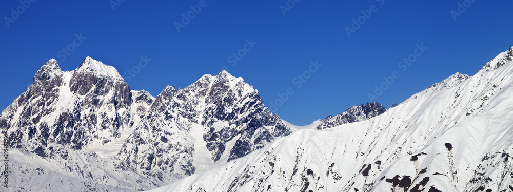 Panoramic view on snowy mountains and blue clear