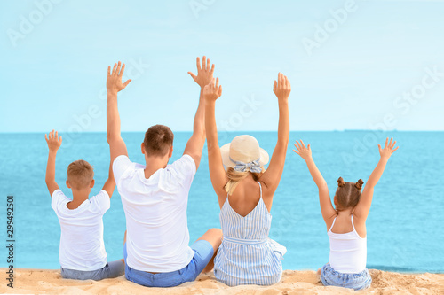 Happy family sitting on sea...