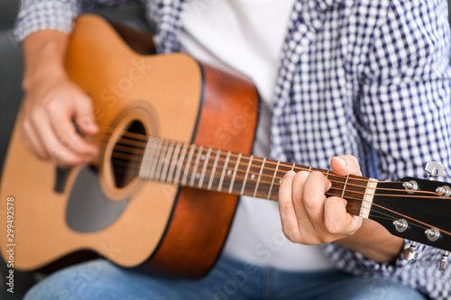 Man playing guitar at home, closeup