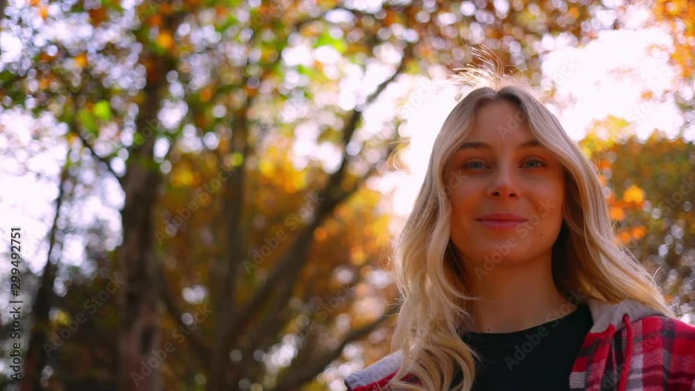 Portrait of pretty blonde woman on nature, young happy girl smiling at camera in autumn garden Portrait of pretty blonde woman on nature, young happy girl smiling at camera in autumn garden
