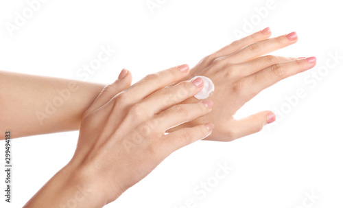 Fototapeta Naklejka Na Ścianę i Meble -  Young woman applying hand cream against white background