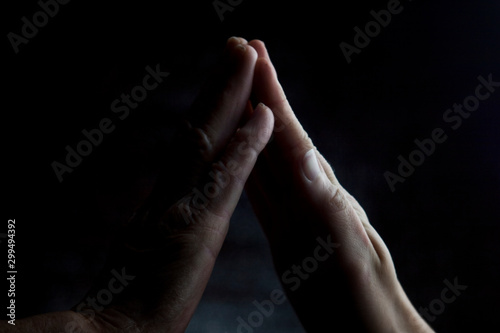 Hands of an old grandmother with young hands of a young girl. Touching palm to palm old mother and child close-up.