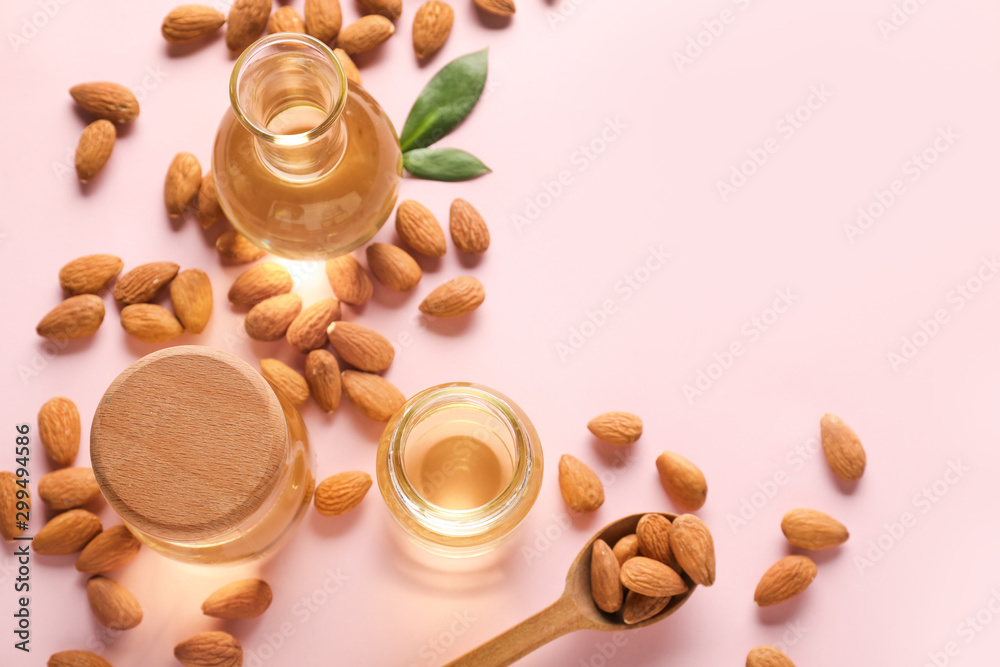 Composition with tasty almonds and oil on color background Composition with tasty almonds and oil on color background